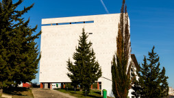 Fotografia da subida para a Escola, com a imagem do edifício e árvores em frente.