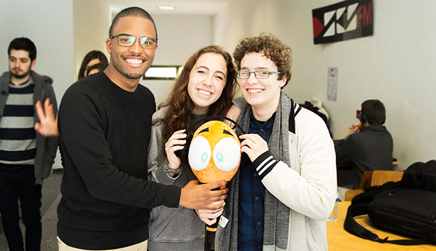 Três membros da ESCS FM, com a mascote do núcleo.